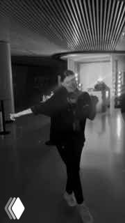 Чёрно‑белый вертикальный фрагмент видео с человеком, делающим экспрессивное движение на фоне интерьера — динамичный элемент рилса для усиления истории бренда.