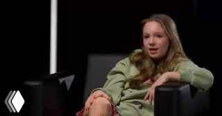 Подросток (Betsy), сидящая в кресле в студийной обстановке во время интервью; кадр подчёркивает возраст и контекст разговора.