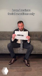 Фотография человека в костюме, держащего лист с надписью 'HBO GO' — шутливый брендовый ревью в формате короткого видео и мемов о ребрендинге.