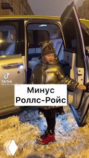 Кадр из ролика: ребёнок в тёплой одежде стоит у открытой двери автомобиля на заснеженной улице, текстовый оверлей «Минус Роллс-Ройс».