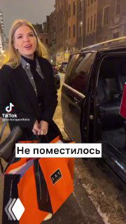 Кадр из ролика: женщина у люксового автомобиля держит большую сумку, на видео текст «Не поместилось» — сценка в развлекательном ключе.
