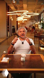 Мужчина жестикулирует в ресторане на фоне интерьера — кадр из серии роликов, демонстрирующий презентацию пиццы и атмосферу заведения.