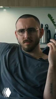 Мужчина в очках разговаривает по телефону в офисном интерьере — кадр из ролика про работу в маркетинге и взаимодействие с клиентами.