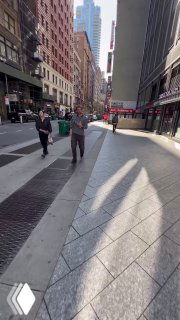 Вертикальный уличный кадр большого города с людьми на тротуаре и архитектурой — контекст съёмки Reels и перенос продукта в городской поток.