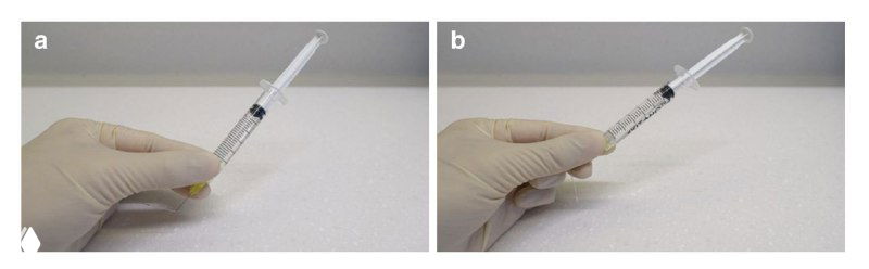 Крупный план шприца со сгибом иглы и видимыми выступами на поршне, иллюстрирующий положение сгиба примерно на треть длины иглы от канюли.