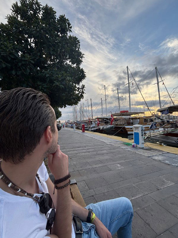 Вид со спины мужчины на набережную с причаленными яхтами и широким облачным небом; референс для замены фона в промптах и тестирования модели.