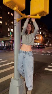 Девушка висит на опоре светофора ночью в городской среде — динамичный уличный кадр для бодрой, энергичной нарезки под вирусный трек.