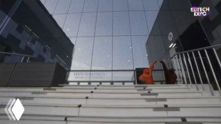 Вид на вход: ступенчатая лестница и площадка у стеклянного фасада здания с логотипом «EdTech Expo», рекламная зона у входа.