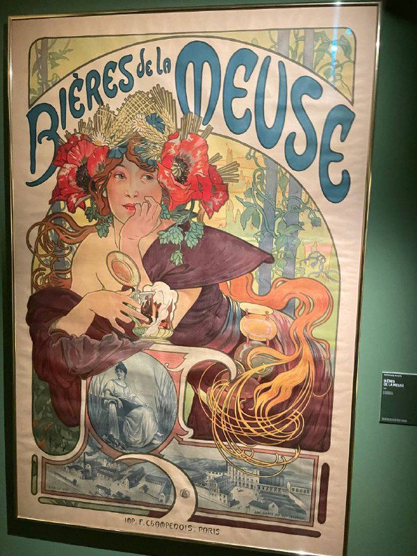 Большой постер или плакат в раме с живой женщиной и яркими декоративными мотивами — экспонат выставки ар‑нуво в музее.