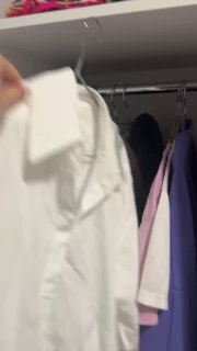 Кадр из видео: белая рубашка на вешалке в шкафу рядом с другими вещами, видны воротник и плечики, контекст хранения и организации гардероба.