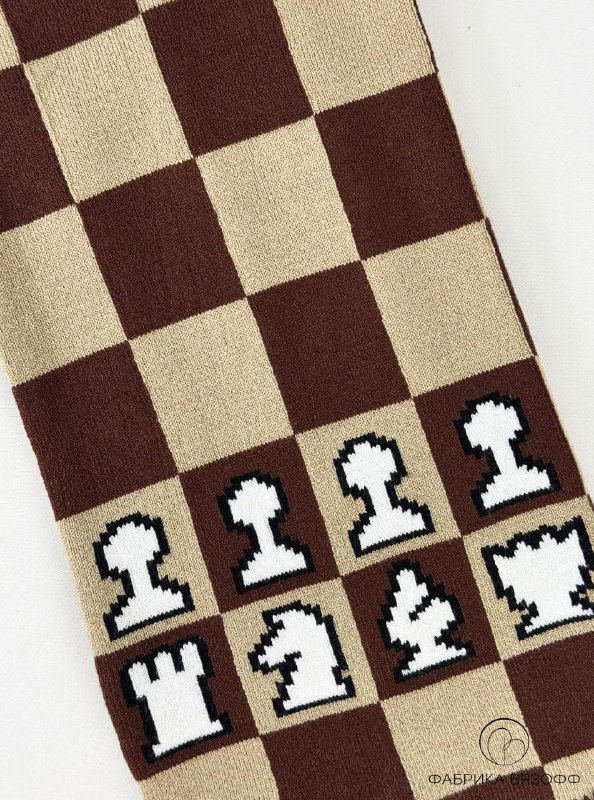 Крупный план поля шарфа: чёткие коричневые и бежевые квадраты, видна плотная фактура полотна и аккуратность вязки в клеточном узоре.