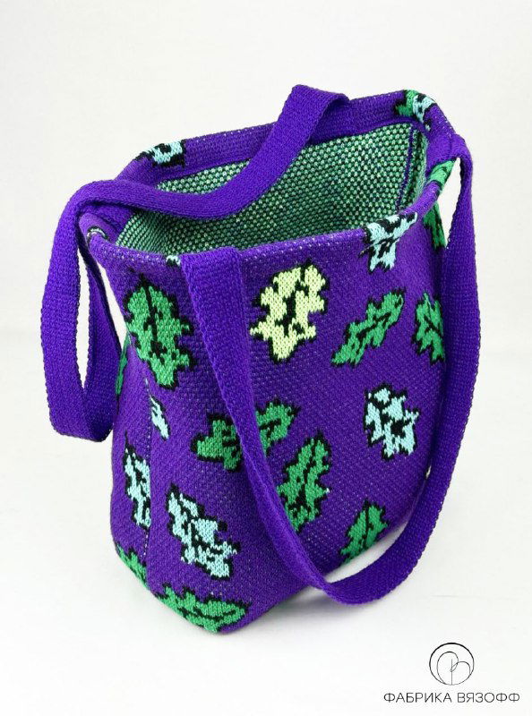 Крупный план фиолетовой сумки‑шоппера с зелёными мотивами, вид сверху‑сбоку; хорошо видна текстура вязки и внутренняя отделка изделия.
