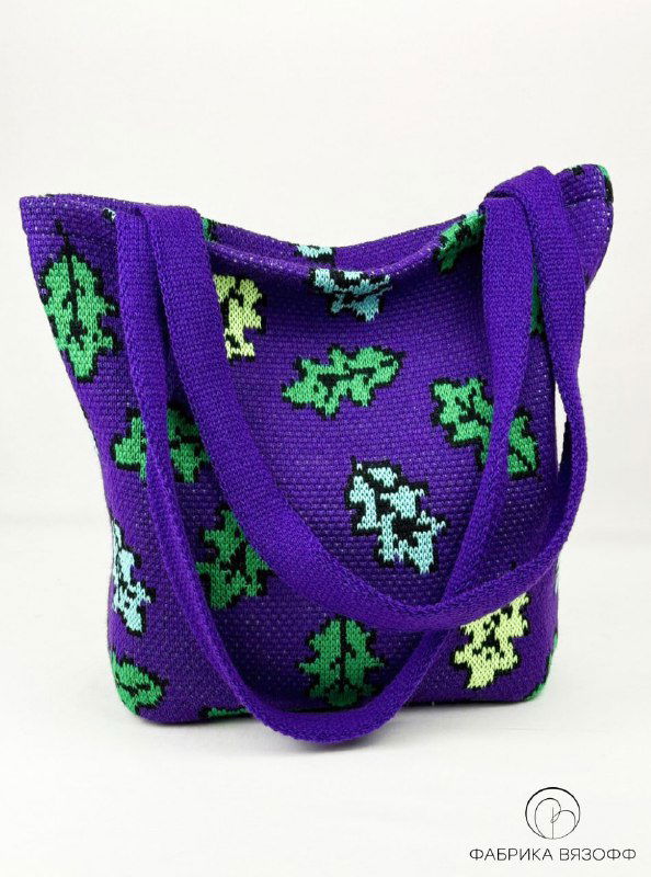 Вид сумки‑шоппера спереди: широкий низ и вертикальные стороны с зелёными рисунками, ровная форма и широкие вязаные ручки для удобной носки.