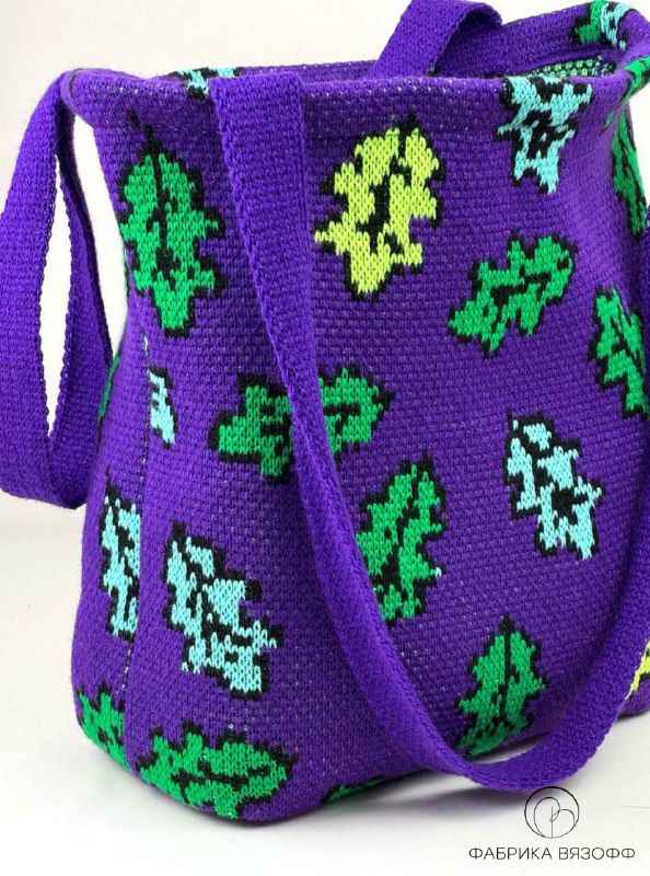 Детальная съемка узора и боковой части фиолетовой вязаной сумки‑шоппера, демонстрация качества шва, плотности полотна и аккуратности исполнения рисунка.