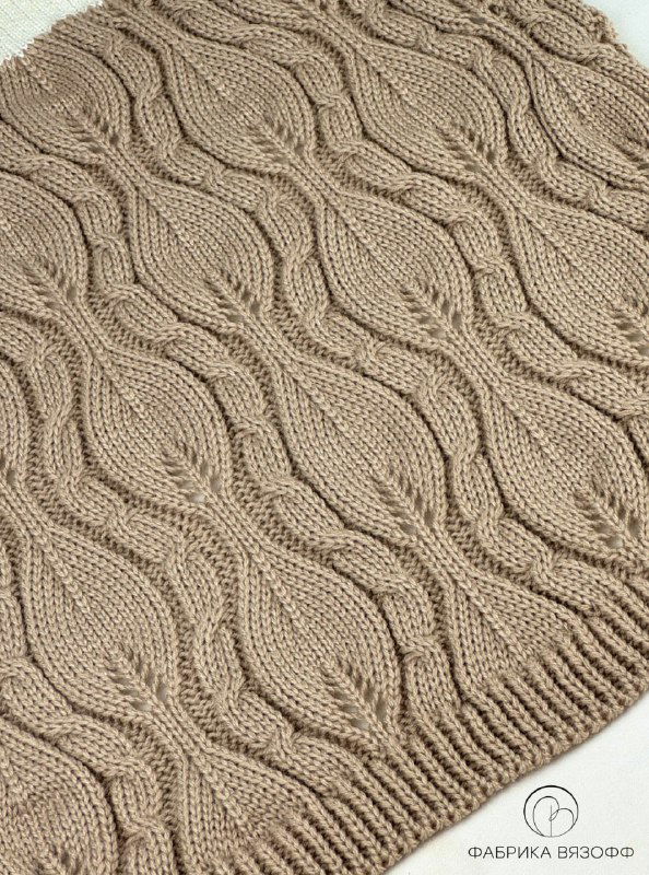 Образец с волнообразными рельефными дорожками и мягкими изгибами узора, демонстрирующий плавность линий в вязании.