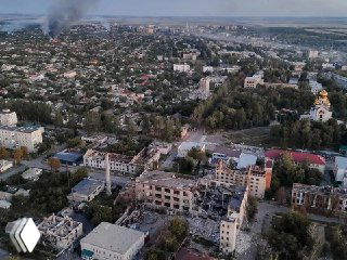 Вид на город Покровск/Красноармейск в Донбассе с разрушенными зданиями и дымом — контекст статьи о последствиях войны и обсуждении использования активов.