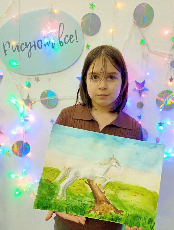 Подросток показывает акварельную работу с белой лошадью на травяном лугу — пример более проработанной техники и светотени.