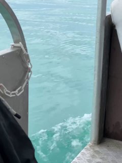 Вид с борта судна на бирюзовую воду у причала, показаны ступеньки палубы и часть металлической ограды — морская прогулка и тренировки.