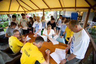 Команда судей и организаторов за столом заполняет протоколы и документы чемпионата, активная административная работа на соревнованиях