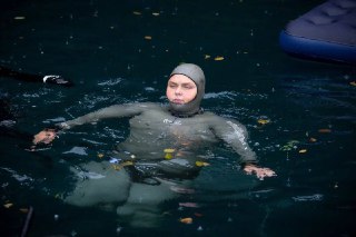Фридайвер в гидрокостюме в воде держится на поверхности после погружения, выражение концентрации и восстановление дыхания