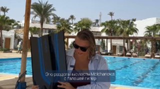 Автор у бассейна держит длинные ласты Molchanovs в руках; на фото видны солнцезащитные очки, отельный бассейн и пальмы на заднем плане.