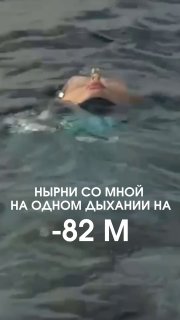 Кадр превью: фридайвер лежит на поверхности воды, видно лицо и окружающую воду; на изображении наложен текст о нырке на −82 м.