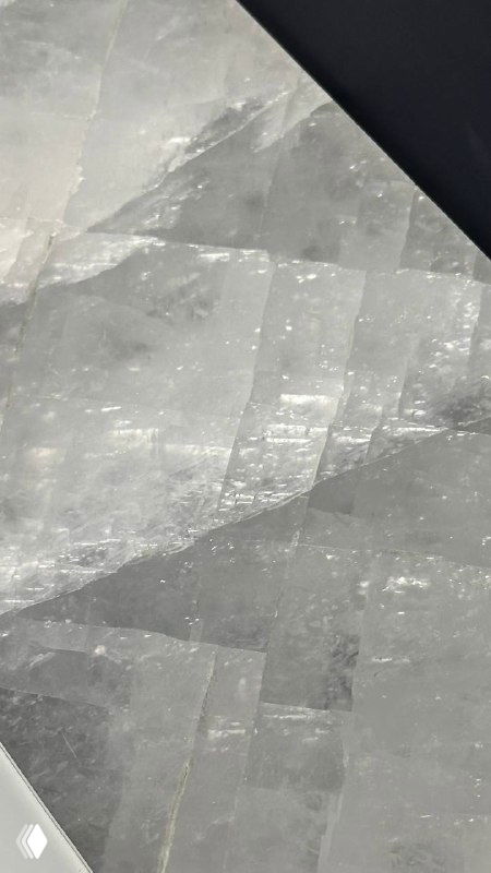 Угол и стык ониксовой плиты: видны трещинки и пластичные переливы светло‑серого камня вблизи поверхности.