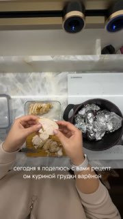 Вид сверху: руки разделяют варёную куриную грудку на рабочей поверхности рядом с кастрюлей, в которой видна фольга и кухонная поверхность.