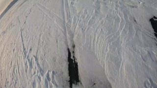 Аэрофотоснимок заснеженного ледяного пейзажа с темной трещиной или разрывом льда, вид сверху, видны следы и рельеф.