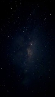 Ночное вертикальное фото звёздного неба, плотное поле звёзд на тёмном фоне, снято с лодки, без ориентиров или людей.