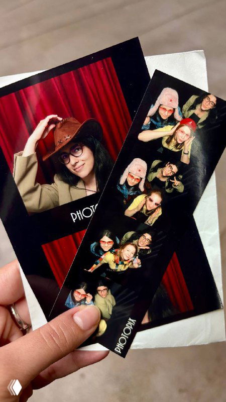 Рука держит распечатанные фотополоски и крупную фотографию: отпечатки с логотипом Photopix на светлом фоне, видны текстура бумаги.