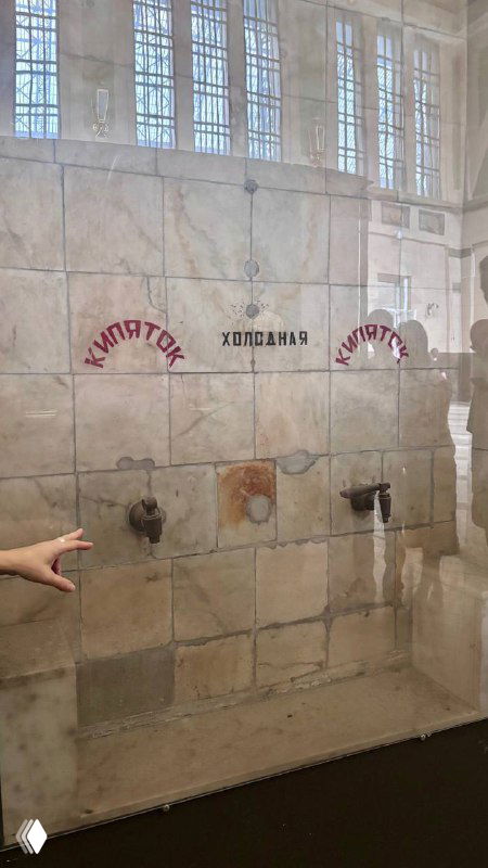 Старинные краны для кипятка в зоне столовой вокзала: настенная плитка, надписи и оригинальные монтажные элементы, используемые пассажирами разных классов.