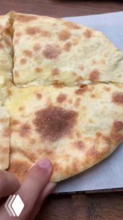 Разрезанный хачапури или шота пури с тянущимся сыром — видна текстура теста и сырная начинка, характерная для пекарни Bagebi.