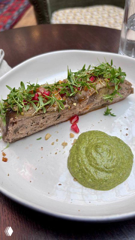 Длинная закуска из овощного паштета или баклажанной намазки, украшенная зеленью и соусом — современная интерпретация грузинских вкусов в Bagebi.