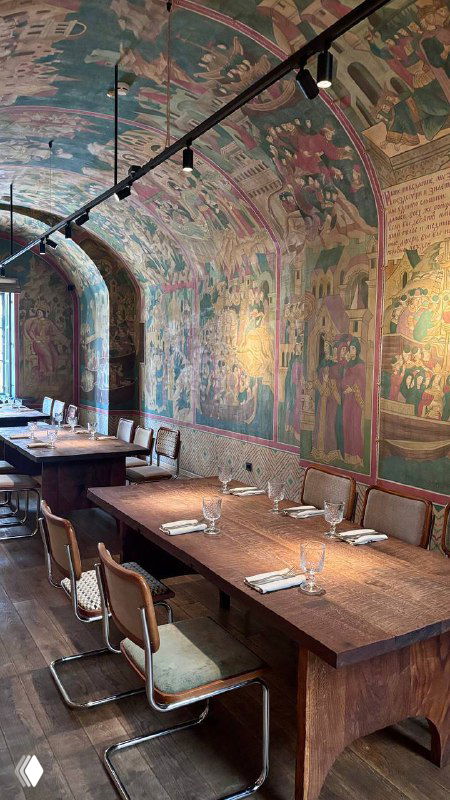 Погребной зал с расписными арками и витражами, длинными деревянными столами и атмосферной подсветкой — интерьер нижнего этажа Bagebi.
