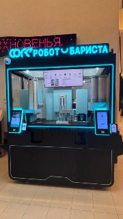 Общий вид автоматизированного киоска «Робот-бариста»: корпус аппарата, экран меню, элементы приготовления и бирюзовая подсветка вокруг.