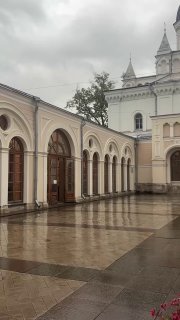 Вид на внутренний двор монастыря и аркаду у буфета после дождя: мокрая мощёная площадь и спокойная архитектура