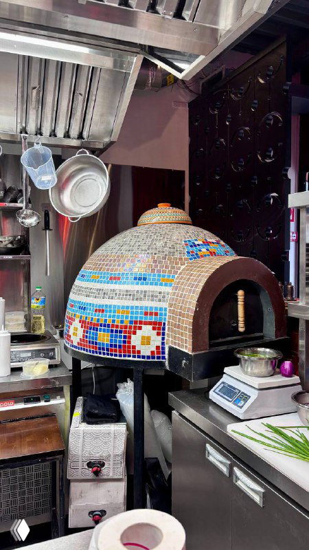 Кухонная печь с мозаичной облицовкой в ресторане Kilim: рабочая зона, декор печи и элементы для выпечки лепёшек и блюд на дровах.