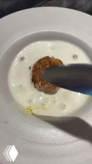 Процесс сервировки: создание пены и финальные штрихи у тарелки с гребешком, демонстрация техники подачи и внимания к деталям.