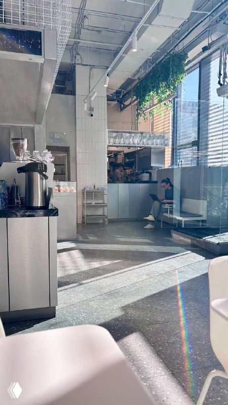 Интерьер rockets: светлый зал с высокой потолочной структурой, большими окнами и минималистичным оформлением — вид изнутри кафе.