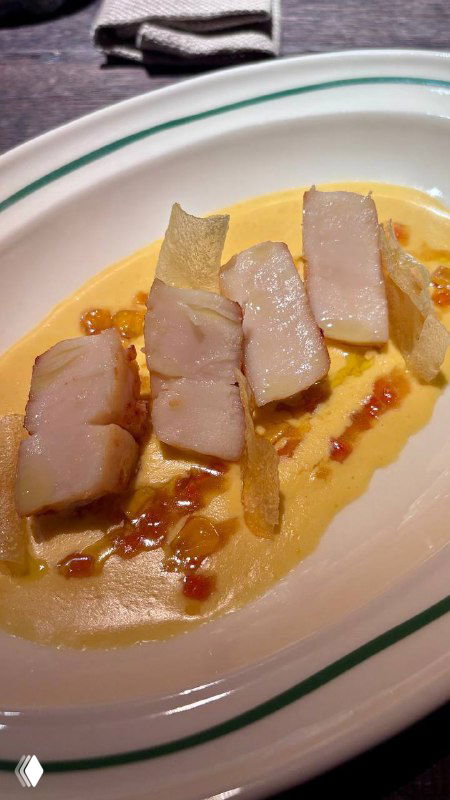 Крупный план блюда: кремовая основа, аккуратно выложенные ломтики и тонкий декор — тарелка в стиле высокой французской кухни, съемка сверху.