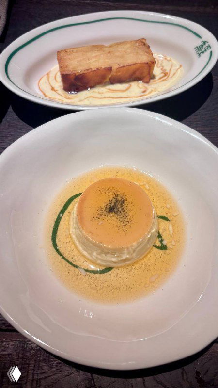 Два небольших блюда на белых тарелках: ломтик хлеба и кремовая подложка, аккуратная подача в минималистичном стиле высокой кухни.