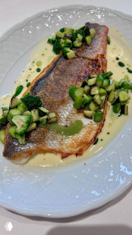 Сибас на белой тарелке с поджаренной корочкой, сливочным соусом и кусочками брокколи — подача ресторана «Поле».