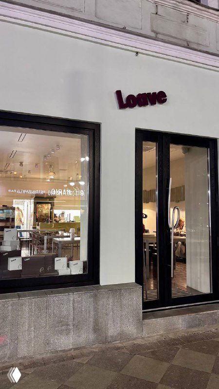 Фасад пекарни Loave с вывеской и витриной в ночной или вечерней подсветке — вид с улицы, вход в заведение.