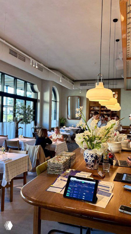 Общий план интерьера ресторана: столы с клетчатыми хлопковыми скатертями, декоративные элементы и мягкое освещение создают уют.