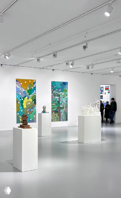 Просторный белый зал МАММ с несколькими постаментами и высокими панно, вдалеке посетители рассматривают произведения на стенах выставки современного искусства.