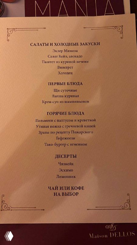 Страница меню с перечислением салатов, горячих блюд и десертов — видна типографика и разделы, снимок вертикальный на столе ресторана.