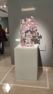 Стеклянная композиция на пьедестале с цветочными мотивами и мягким боковым освещением, общий вид одного из экспонатов выставки «Степени прозрачности».