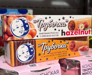 Две коробки вафельных трубочек марки завода им. В.П.Пастухова на полке магазина, видны названия вкусов и оформление упаковки.