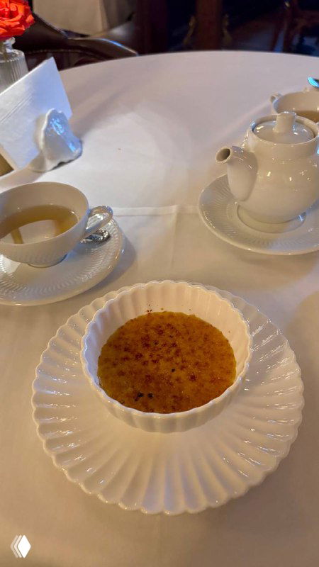 Десерт и чаепитие в Шануар: крем-брюле в белой посуде, рядом чайник и чашка на столе, тёплая приятная сервировка ресторана.